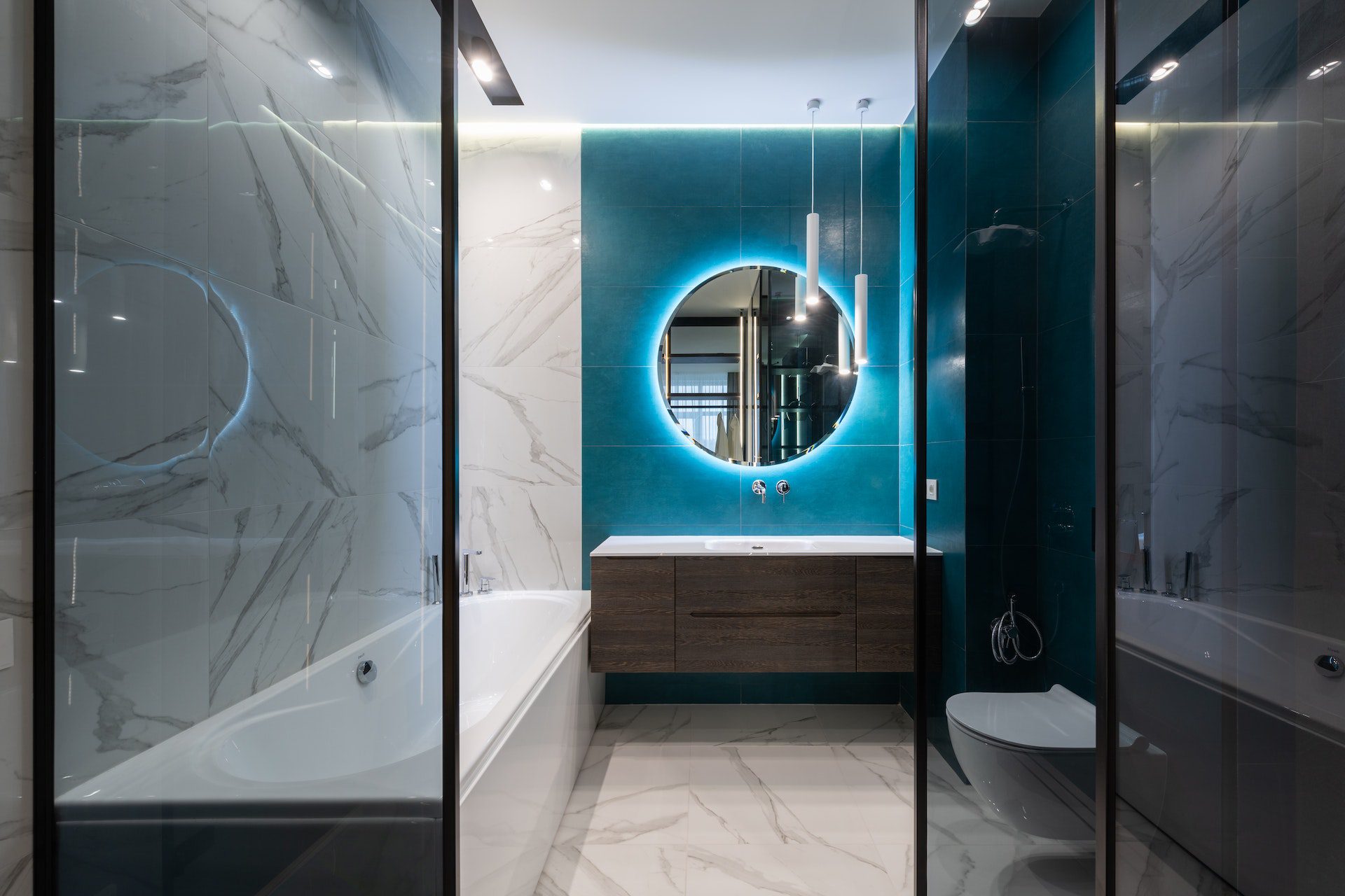 Contemporary interior of bathroom with bathtub and round mirror Contemporary interior of bathroom with bathtub and round mirror